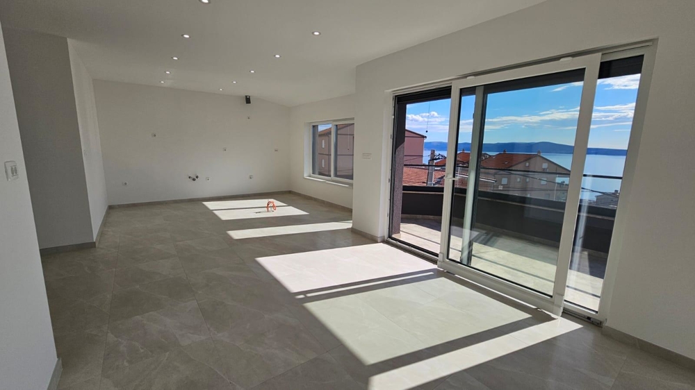 Soggiorno inondato di sole dell'appartamento in vendita a Crikvenica con accesso al balcone e vista sulla costa