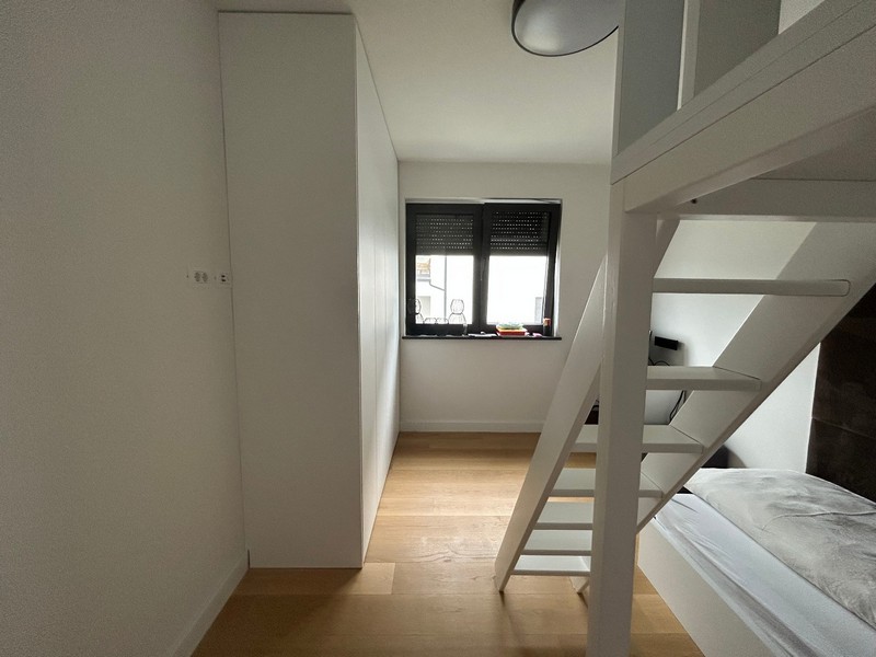 Seconda camera da letto con letto a soppalco e zona lavoro in un moderno appartamento a Rijeka, Croazia.