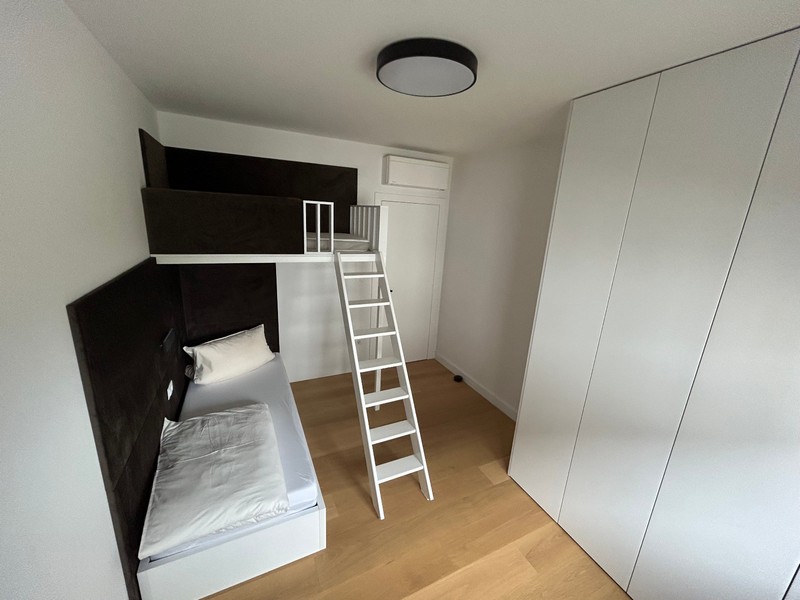 Camera da letto minimalista con letto a soppalco e scala in un moderno appartamento a Rijeka.