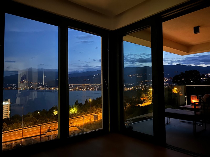 Vista notturna dal balcone di un appartamento a Rijeka sulla costa illuminata.