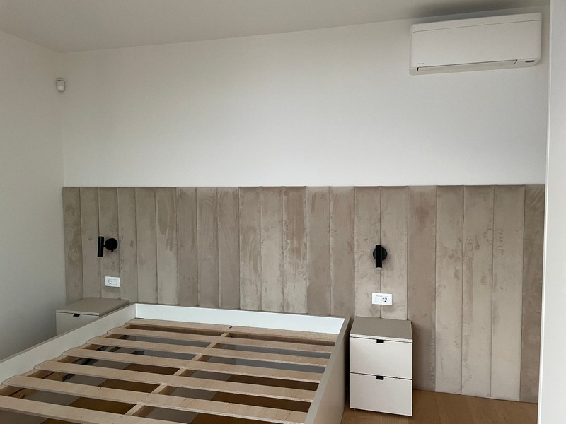 Camera da letto minimalista con letto a incasso e aria condizionata in un appartamento a Rijeka.