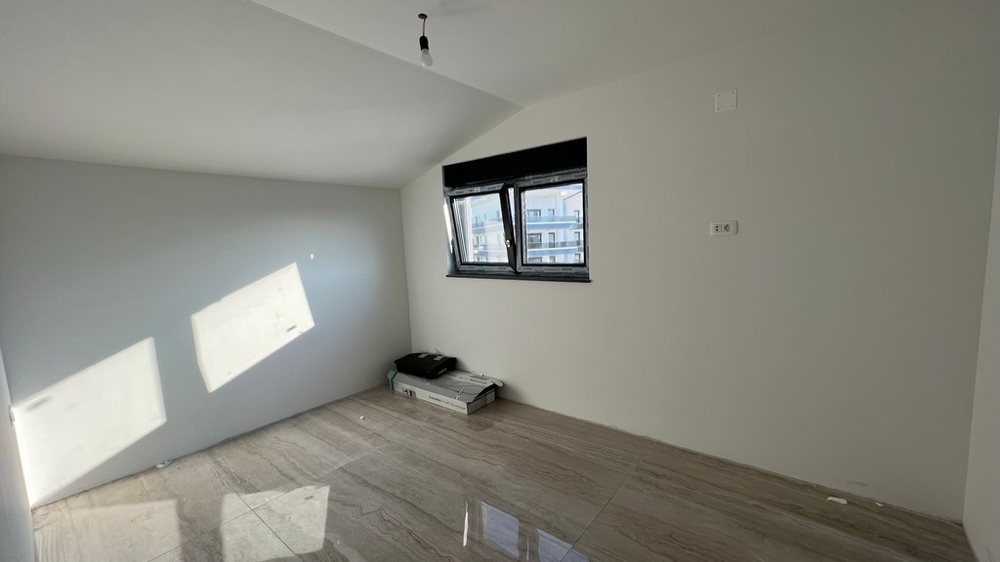 Soggiorno dal design minimalista con pavimento piastrellato chiaro, adatto a immobili moderni in Croazia.