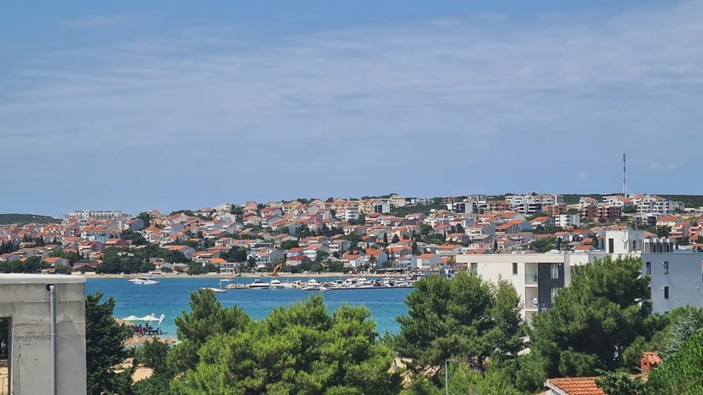 Vista panoramica di Novalja, isola di Pag, con appartamenti e la costa blu del mare, immobili Croazia