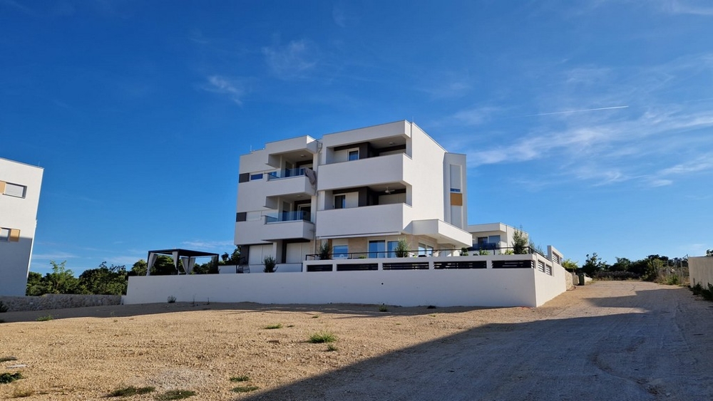 Vista frontale di un moderno edificio di appartamenti bianco a Novalja, isola di Pag, immobili Croazia