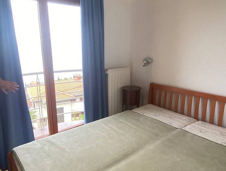 Camera da letto con letto matrimoniale e porta del balcone