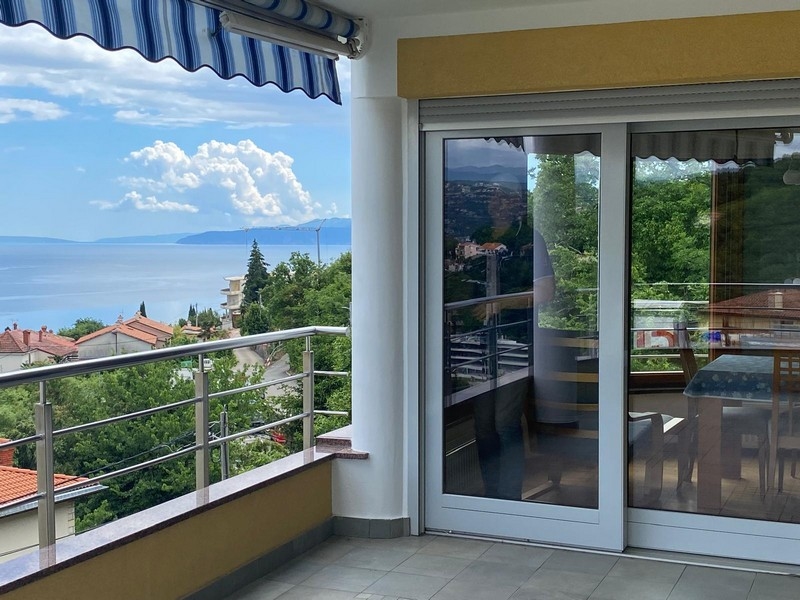 Balcone con porta scorrevole in vetro e ampia vista mare