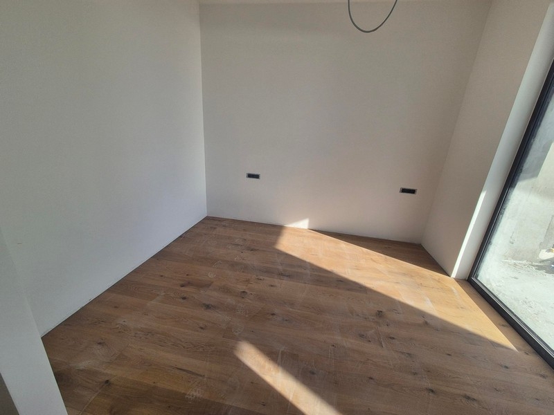 Camera da letto con parquet e finestra a tutta altezza