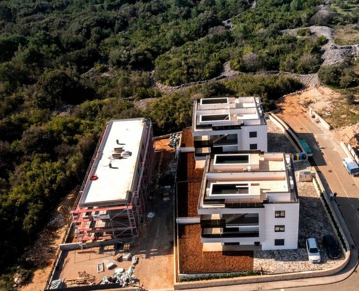 Vista aerea degli edifici nuovi sul pendio boscoso con cantiere
