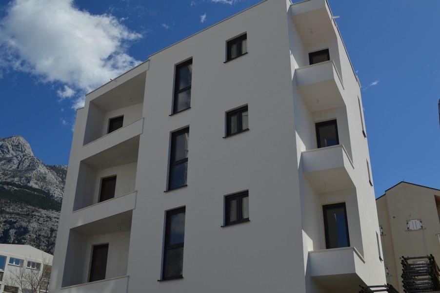 Edificio nuovo bianco con logge davanti alla catena montuosa