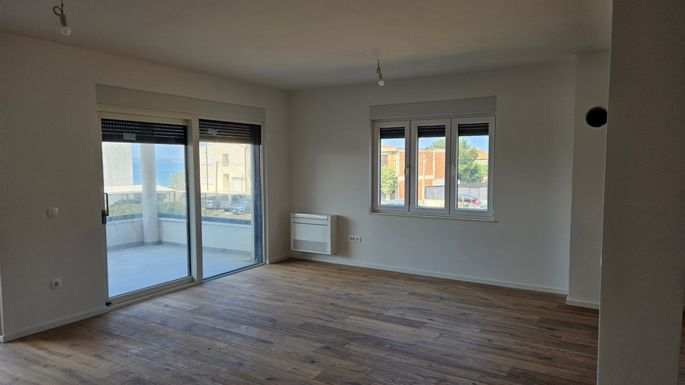 Zona giorno con parquet e radiatore a parete.