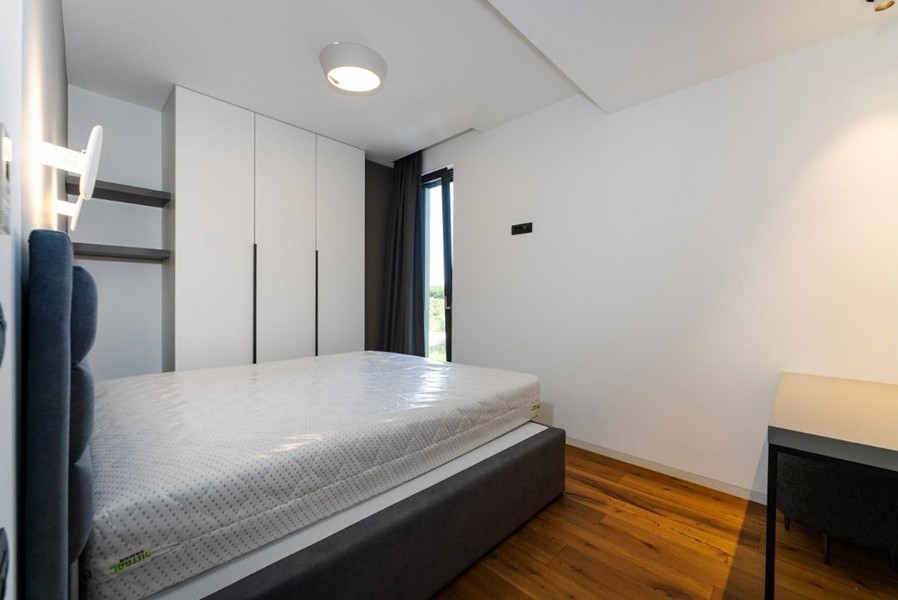 Camera da letto con armadi bianchi, letto grigio, scrivania