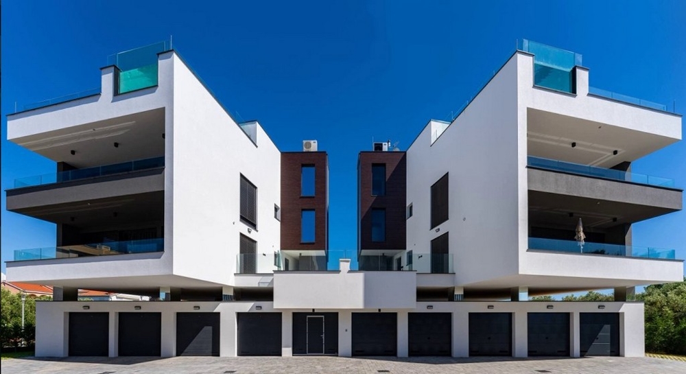 Due edifici speculari con fila di garage nel basamento