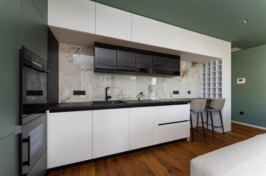 Cucina moderna con rivestimento in marmo, ante nere e bianche