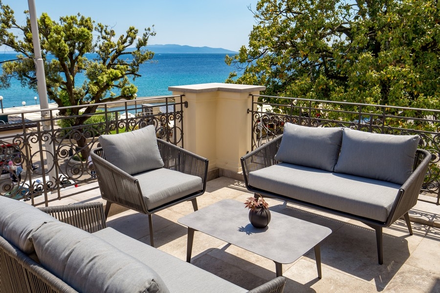Terrazza con mobili lounge dietro una ringhiera in ferro battuto