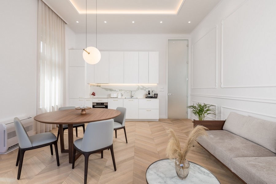 Soggiorno luminoso con tavolo da pranzo, sedie, cucina e divano