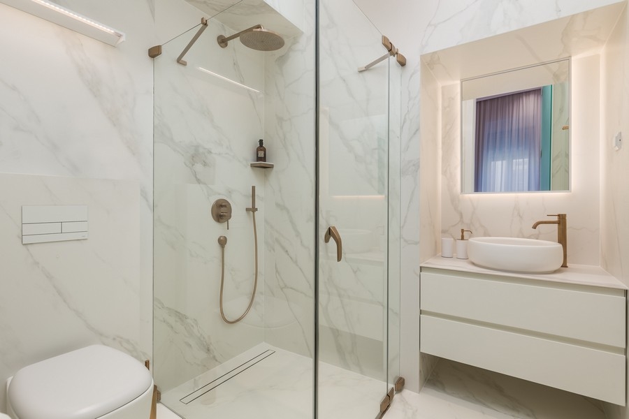Bagno moderno con doccia in vetro e piastrelle in marmo