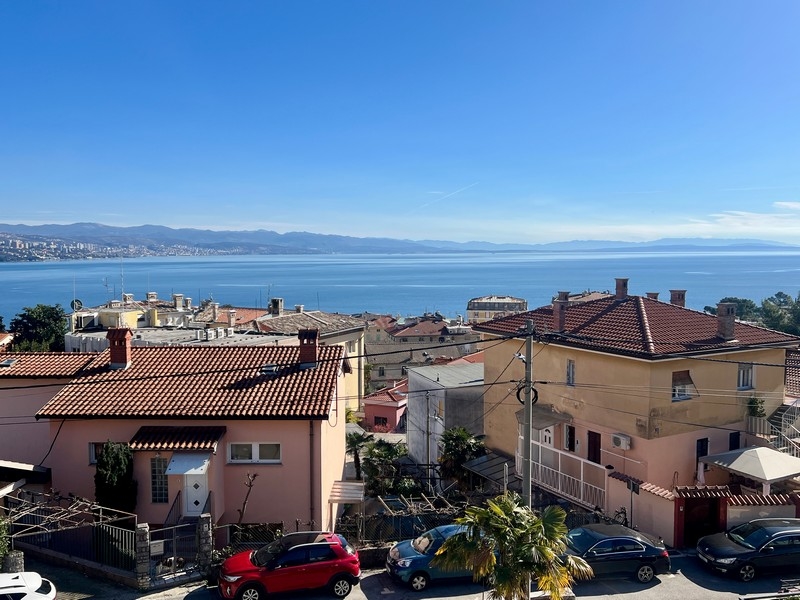 Vista sui tetti di tegole e sulle auto fino all'ampia baia