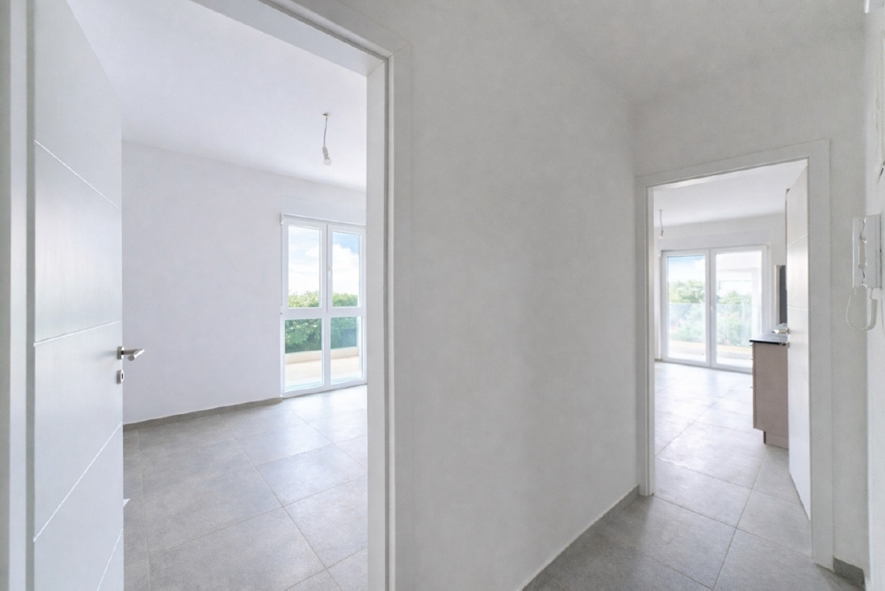 Panoramica di un cantiere in una zona residenziale, con case e il mare sullo sfondo
