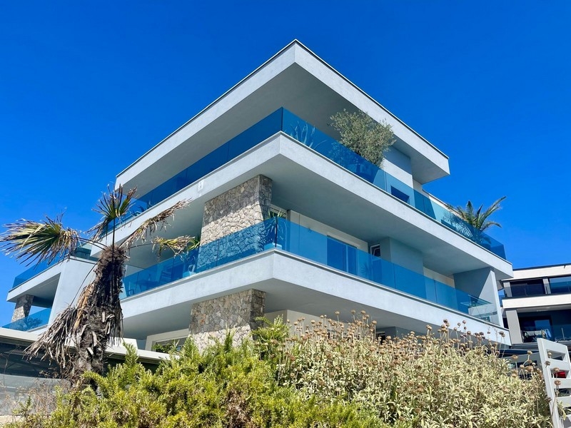 Edificio con parapetti in vetro blu e colonna in pietra naturale