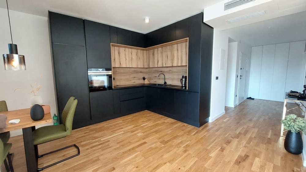 Cucina componibile nera con pannello posteriore in legno e parquet