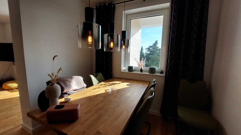 Tavolo da pranzo in legno con lampade a sospensione alla finestra