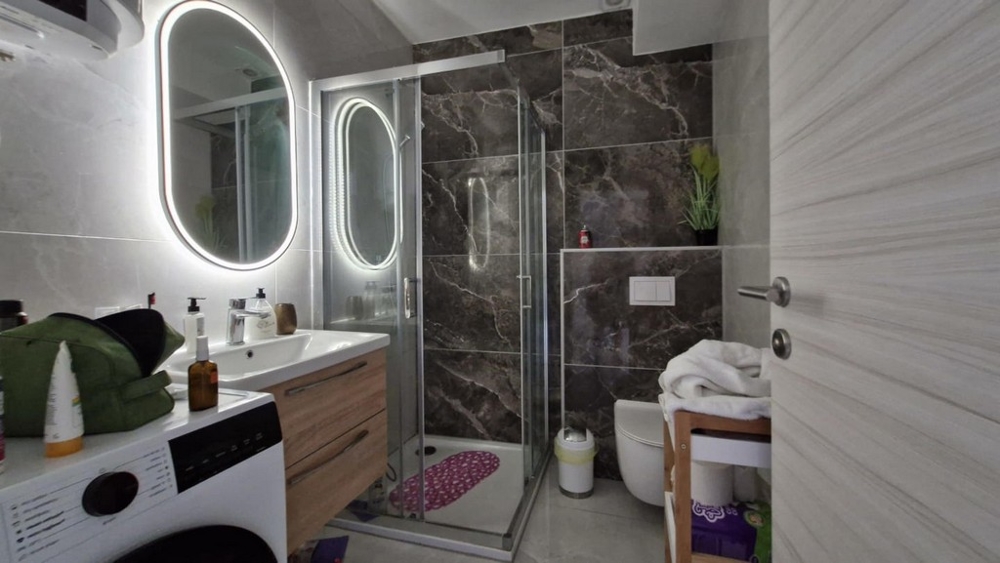 Bagno con doccia, lavabo e lavatrice