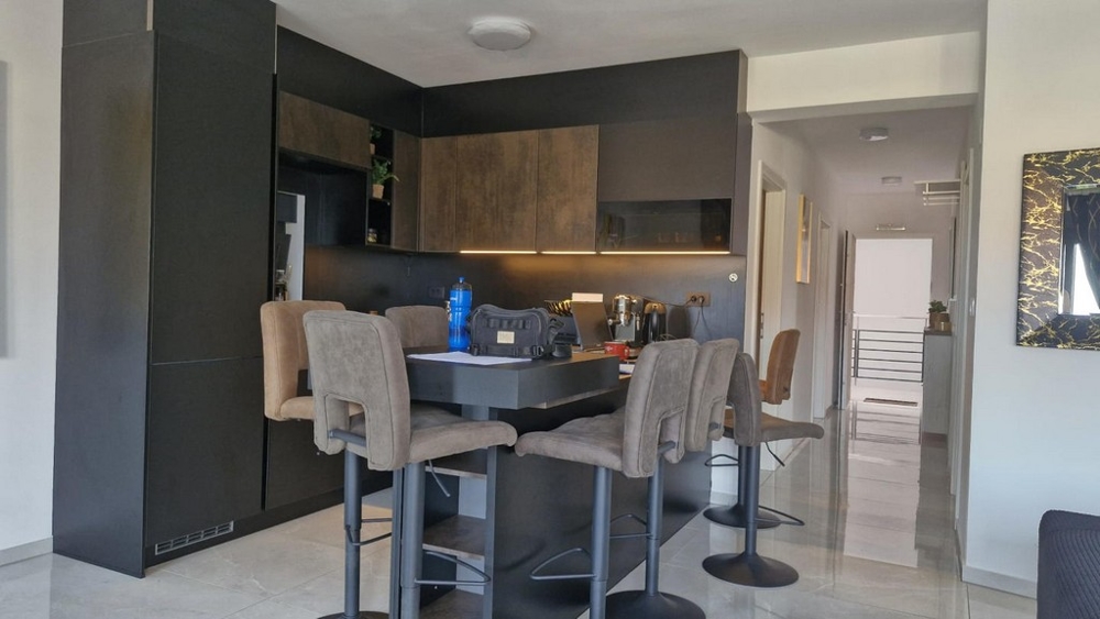 Cucina moderna con sgabelli da bar e tavolo da pranzo