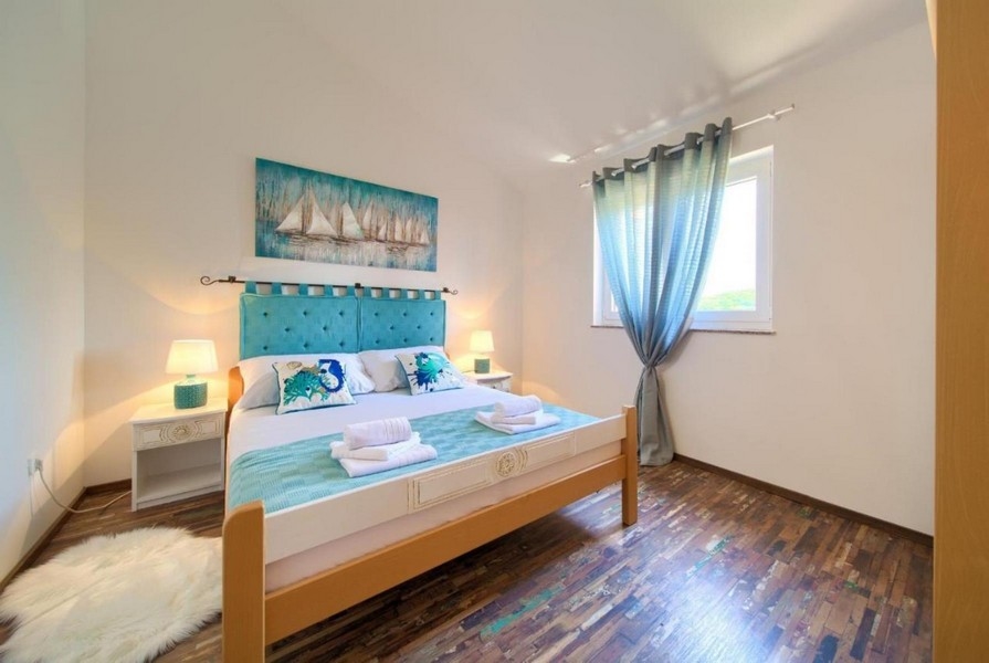 Camera da letto con letto matrimoniale, testiera turchese ed elementi decorativi marinari