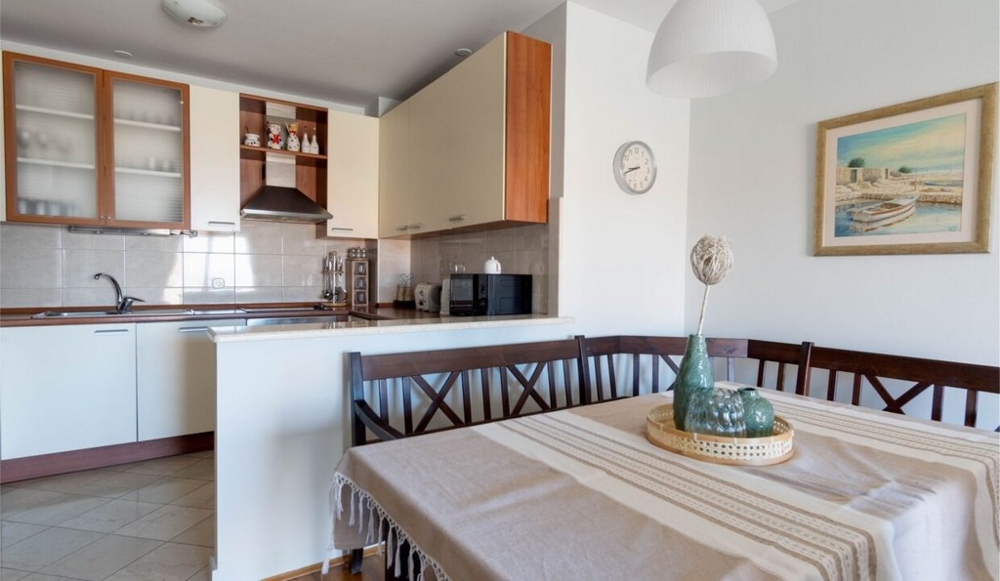 Tavolo da pranzo e vista sulla cucina dell'appartamento A3462.