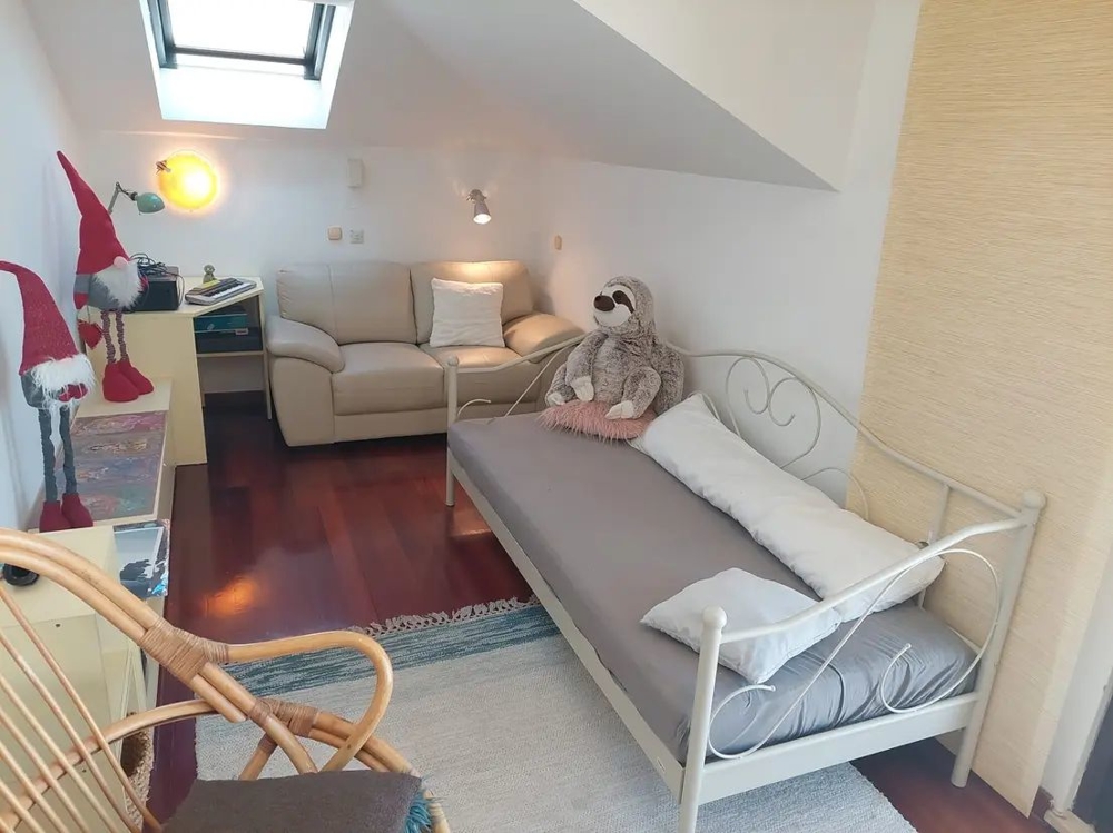 Camera con letto, divano, lucernario e decorazioni, con peluche
