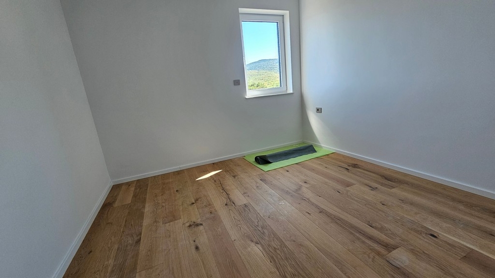 Camera da letto con parquet di rovere e finestra con vista mare, appartamento di nuova costruzione A3480