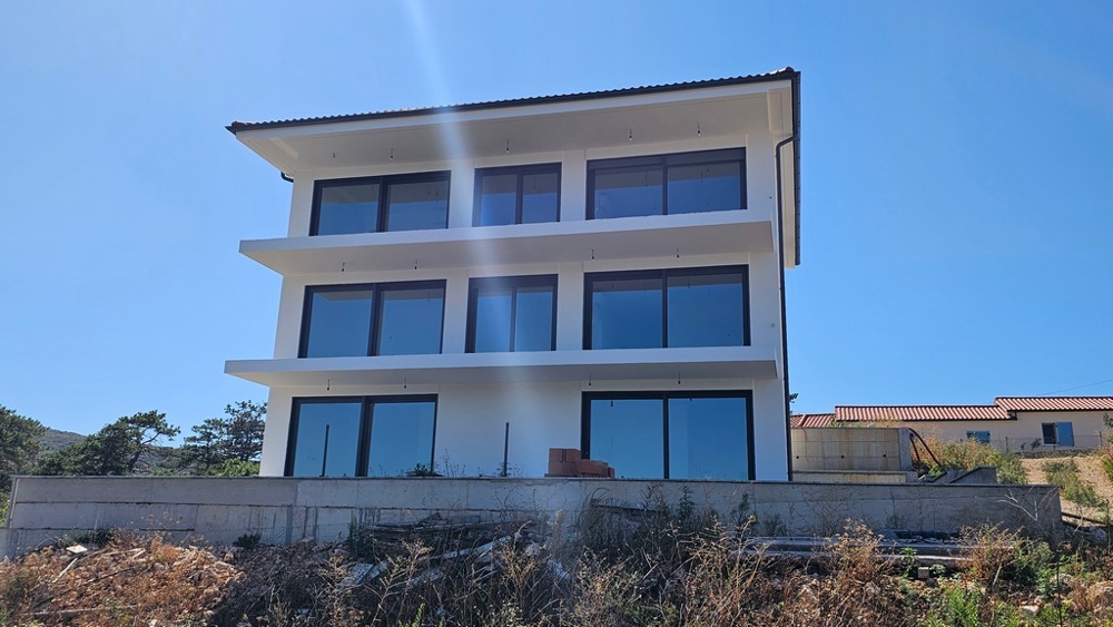Vista frontale della nuova costruzione con balconi e vetrate a Vrbnik, Croazia