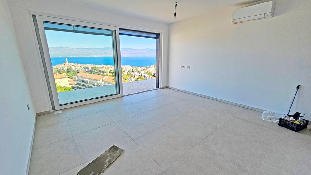 Zona giorno con porta scorrevole e vista su Vrbnik e sul mare, appartamento A3481 al 2° piano