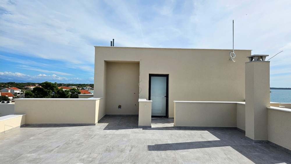 Terrazza sul tetto con porta d'accesso che conduce a un'area coperta
