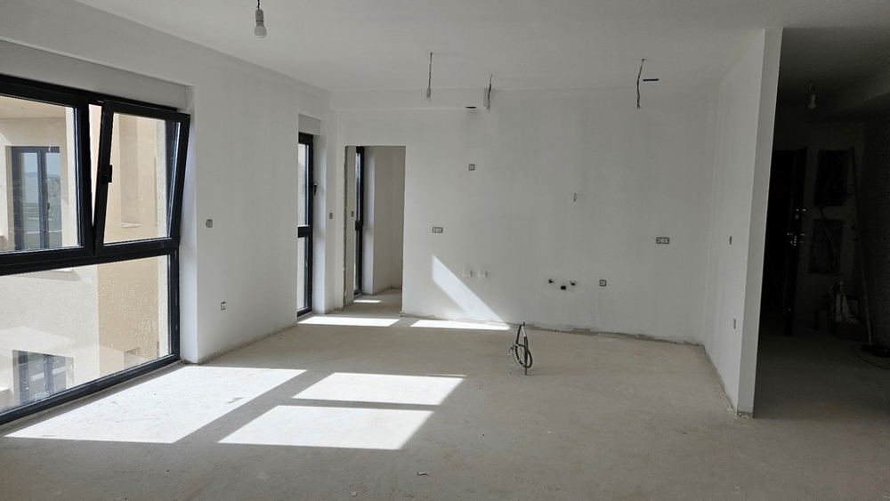 Interno non finito con molta luce naturale, accessibile attraverso grandi finestre