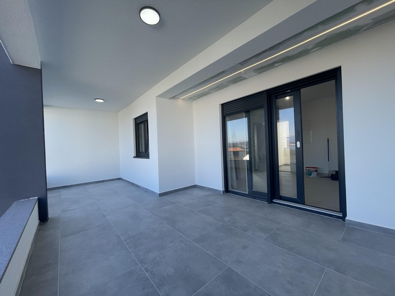 Ampia terrazza con pavimento piastrellato e illuminazione