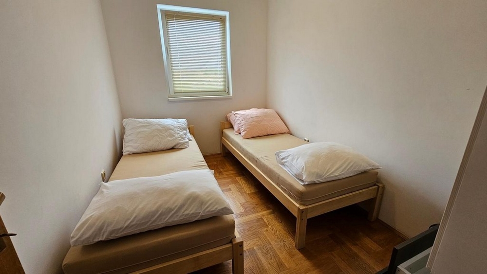 Piccola camera da letto con due letti singoli.