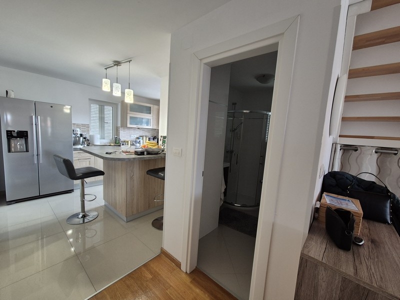 Cucina aperta con isola, sgabelli da bar e accesso al bagno