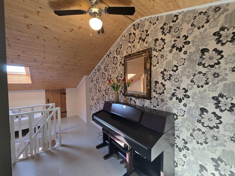 Piano superiore con pianoforte e soffitto mansardato
