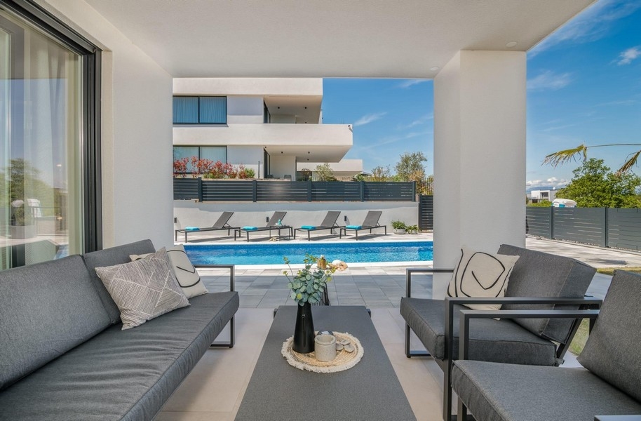 Terrazza con vista sulla piscina e lettini prendisole
