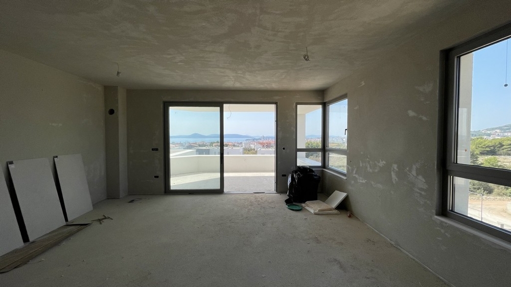 Zona giorno e pranzo aperta con vetrata e vista mare, attico A3577 in costruzione.