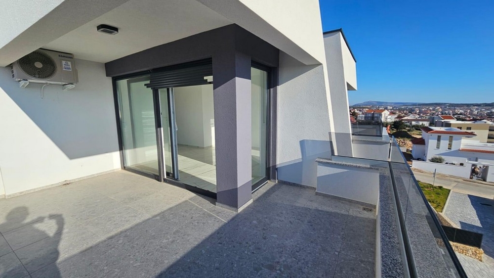 Terrazza con lastre scure e porta scorrevole verso la stanza