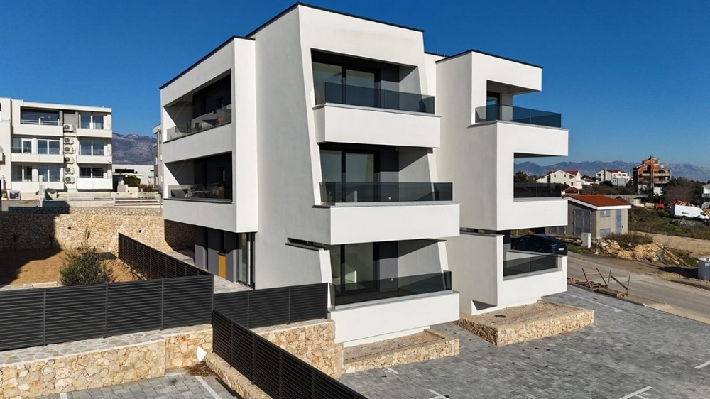Complesso residenziale moderno con balconi e posti auto