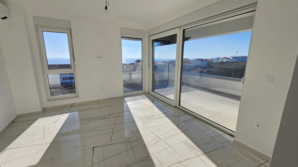 Zona giorno luminosa con finestre panoramiche e vista mare