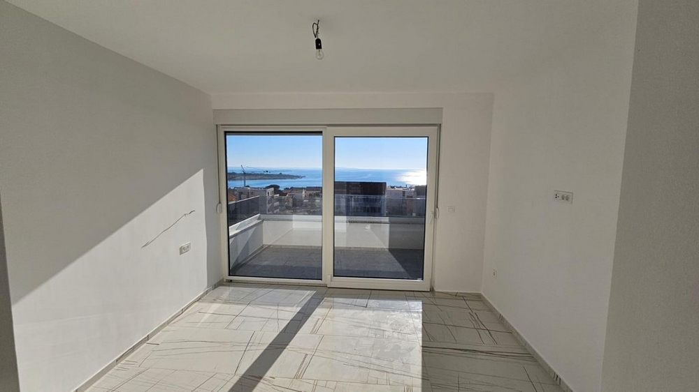 Camera da letto con grande vetrata e vista mare