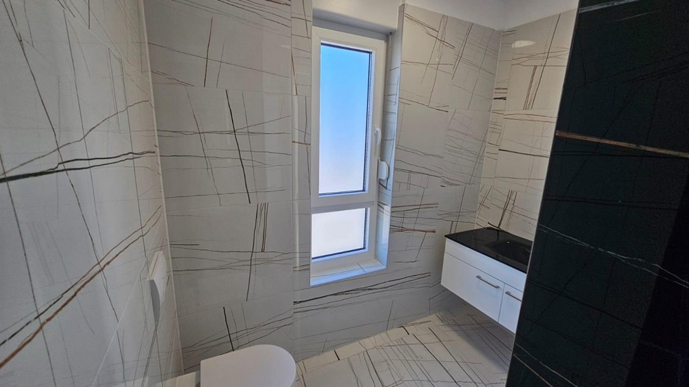 Bagno con moderne piastrelle e finestra