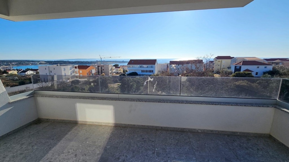 Loggia con parapetto in vetro e vista sul paese fino all'acqua