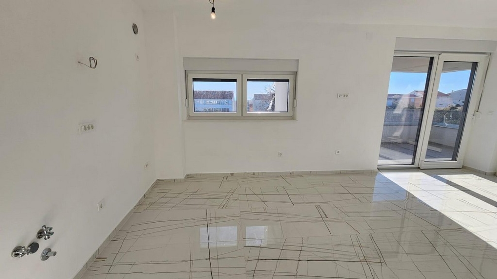 Zona giorno con pavimento piastrellato e accesso alla terrazza