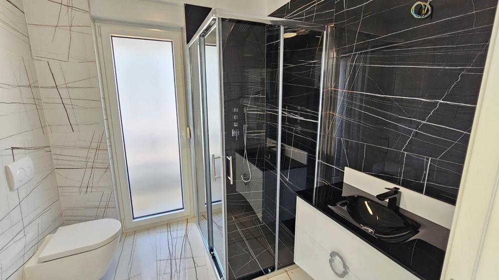Elegante bagno con doccia nera e lavabo