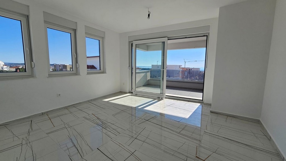 Soggiorno luminoso con balcone e vista mare.